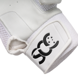Close-up of a white boxing glove showing the textured leather panel, white mesh padding, and a white hook-and-loop strap with a black stylized logo.